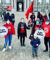 A group of people demonstrating in red clothes and with red banners.