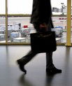 A shot of a man's legs walking in an airport with a briefcase.